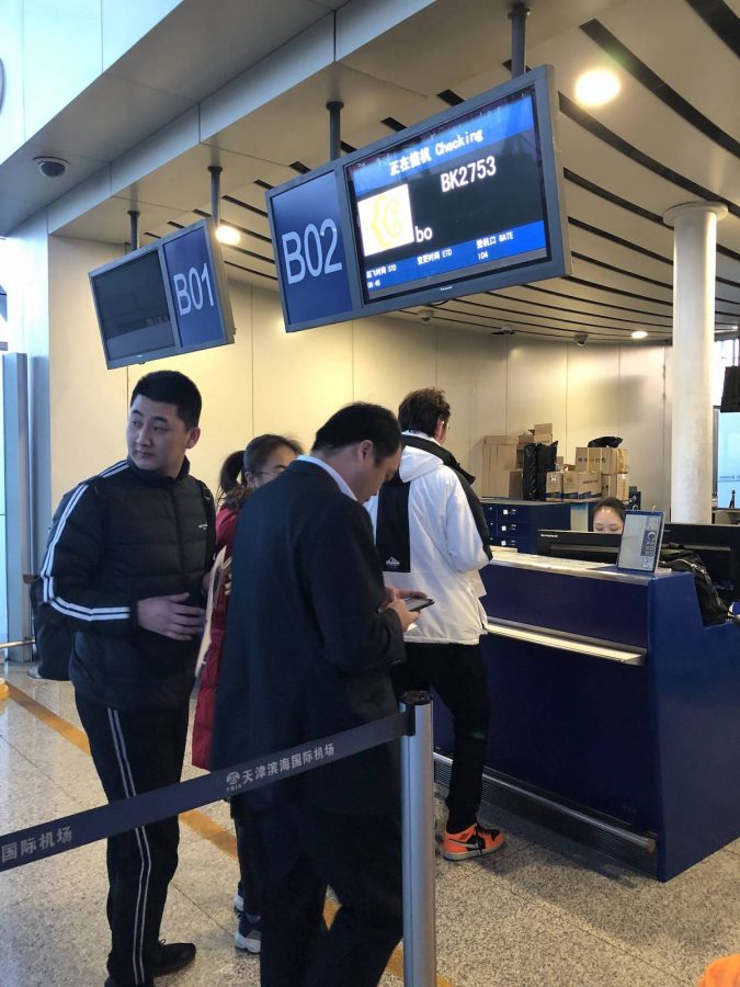 他们在安检的最前面，王总在回头看什么？